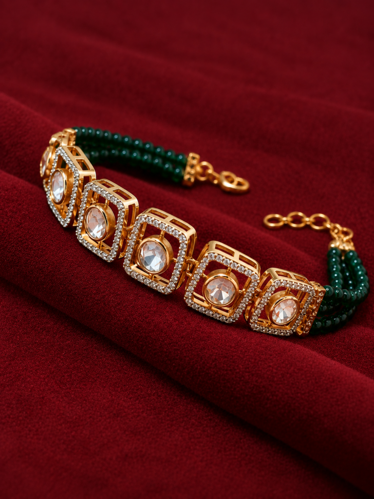 gold and emerald bracelet on burgundy velvet